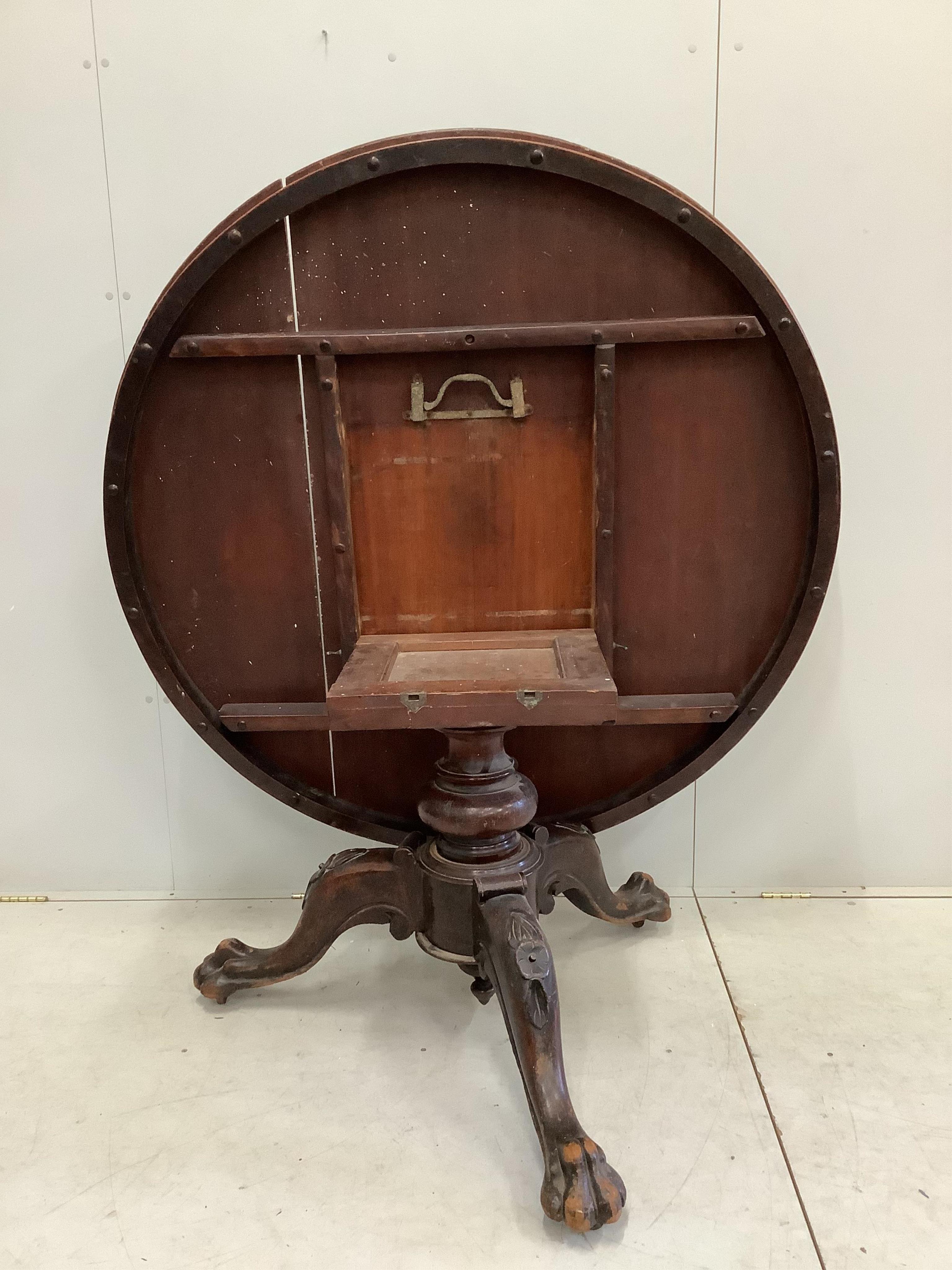 A Victorian circular mahogany tilt top tripod breakfast table with claw feet, diameter 136cm, height 72cm. Condition - poor